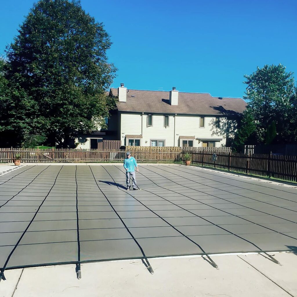 Custom mesh safety cover secured over a swimming pool